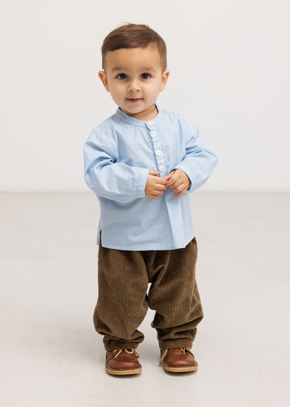 Light blue shirt with button closure in front and short sleeves on model