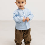 Light blue shirt with button closure in front and short sleeves on model