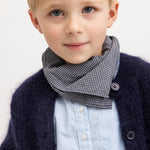 Light blue striped shirt with visible buttons under a dark cardigan.