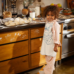 Apron in nature with a blue cat motif, bow at the waist, and buttons on the shoulders.