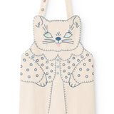 Natural-colored apron with cat appliqué, blue embroidery, and shoulder button closure.