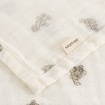 Soft cream-colored cotton with small teddy bear print and visible edge.