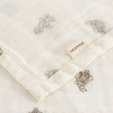 Soft cream-colored cotton with small teddy bear print and visible edge.