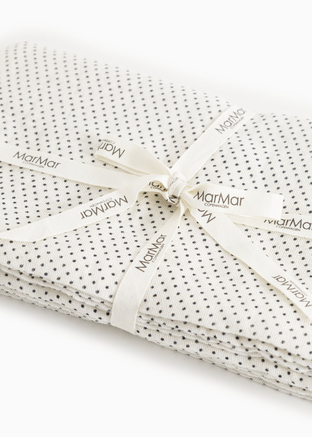 Cream rug with black dots, corded with ribbon and marMar labels.