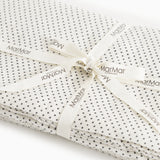 Cream rug with black dots, corded with ribbon and marMar labels.