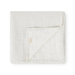 Cream blanket with small black dots, folded square, with a marMar flap.