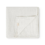 Cream blanket with small black dots, folded square, with a marMar flap.