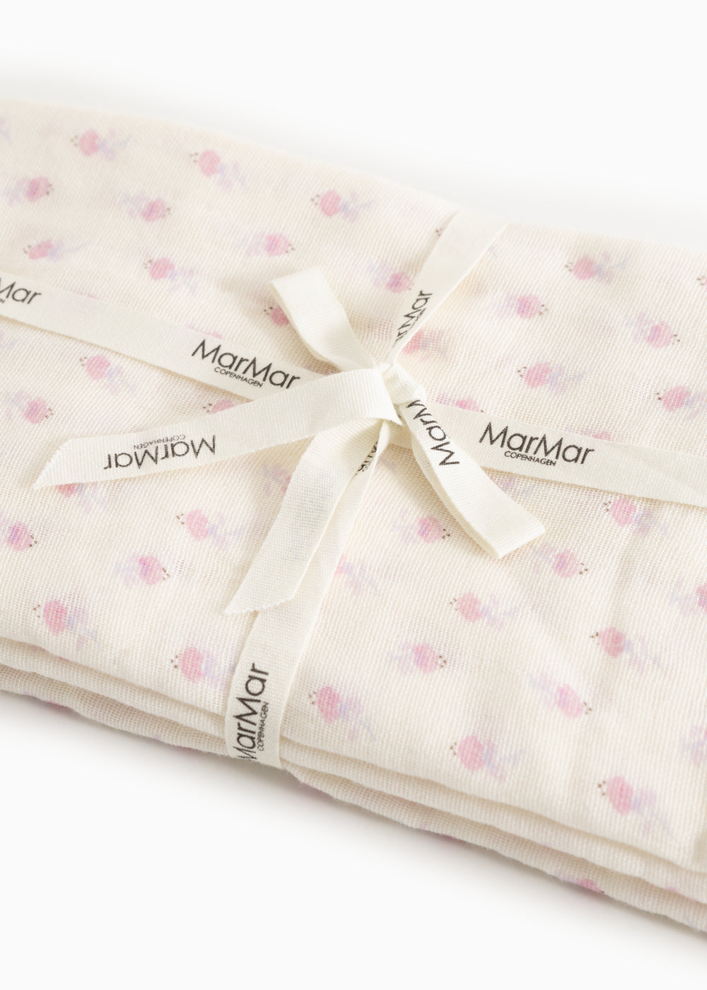 Baby wrap with loose tied strap and MarMar labels in cream-colored floral pattern.