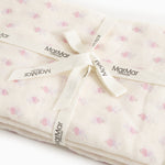 Baby wrap with loose tied strap and MarMar labels in cream-colored floral pattern.