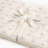 Baby wrap with loose tied strap and MarMar labels in cream-colored floral pattern.