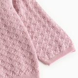 Pink baby knit cardigan with a fine pattern and ribbed hem, as well as at the sleeves.