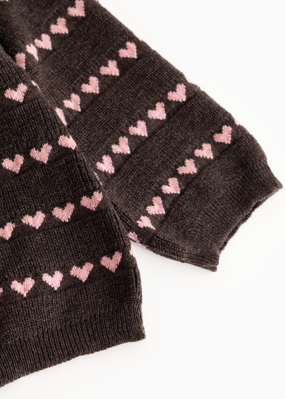 Sort strikbluse med lyserøde hjerter og ribkant ved ærmerne

Black knit blouse with pink hearts and ribbed cuffs.