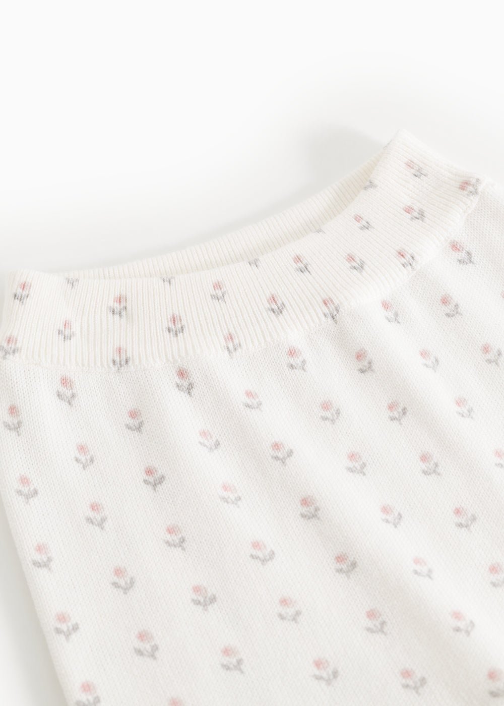 Elastic-waisted trousers with elastic ribbing at the waist and repeated floral pattern.