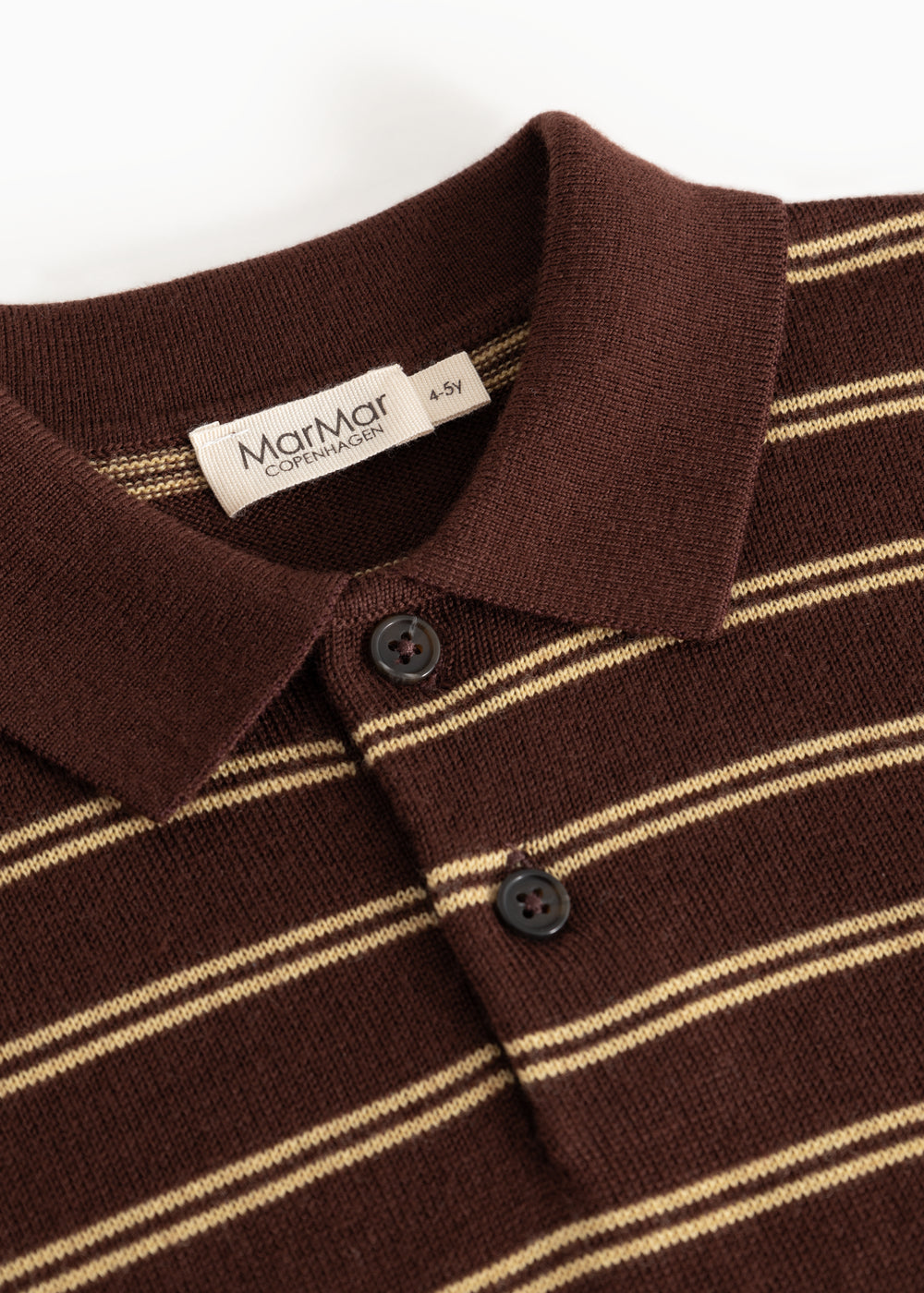Details of the striped polo: ribbed, buttons and beige stripes on a dark background.