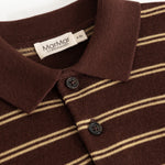 Details of the striped polo: ribbed, buttons and beige stripes on a dark background.