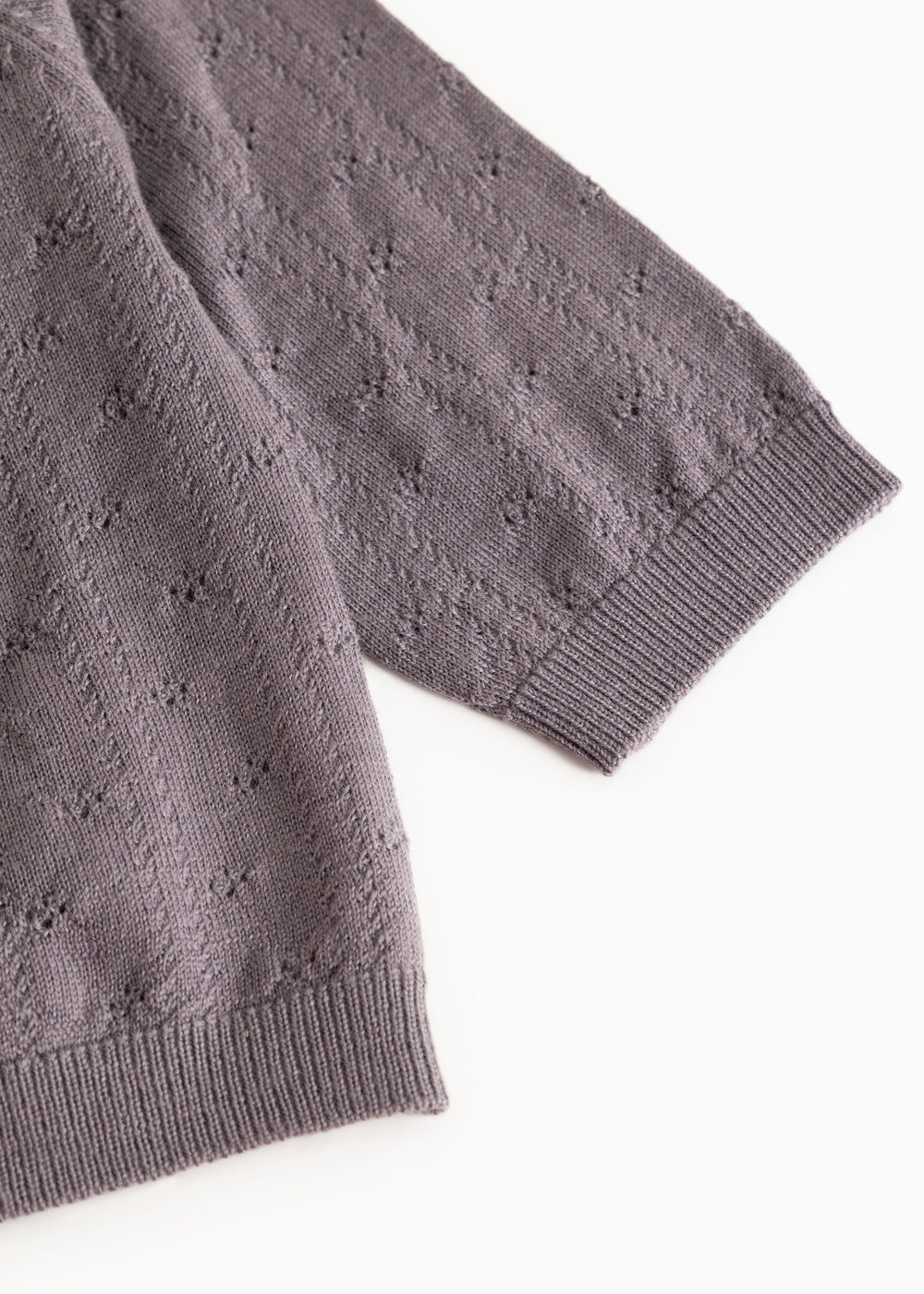 Dark purple knitted cardigan with ribbed edge and pattern in the fabric.