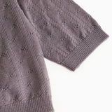 Dark purple knitted cardigan with ribbed edge and pattern in the fabric.