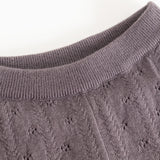 Dark purple knit trousers with ribbed lining and a delicate polka dot pattern.