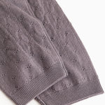 Dark purple knit trousers with ribbed edge and fine polka dot pattern at the leg opening.