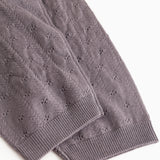 Dark purple knit trousers with ribbed edge and fine polka dot pattern at the leg opening.