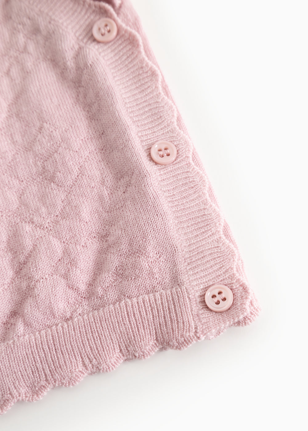 Pink knit cardigan with buttons and ribbed edge at the bottom and sleeves.