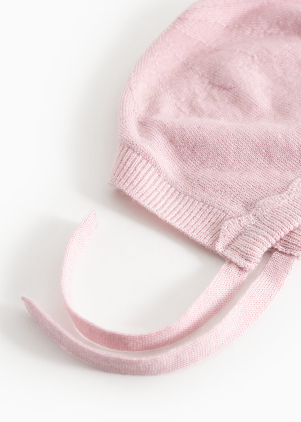 Pink knit hat in knit with folded edge and two drawstrings