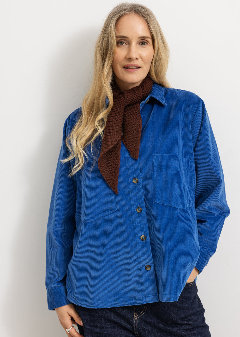 Dark wine-red knitted scarf worn by a woman with a blue shirt