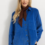 Dark wine-red knitted scarf worn by a woman with a blue shirt