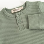 Long-sleeved bodysuit in frost green ribbed fabric with button placket and round buttons at the neck