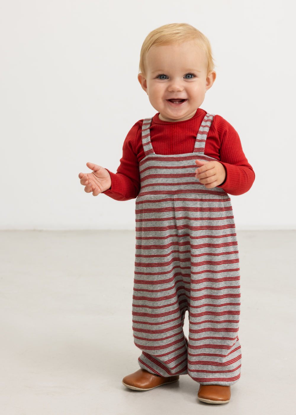Romper with red stripes and shoulder straps, worn by a small child