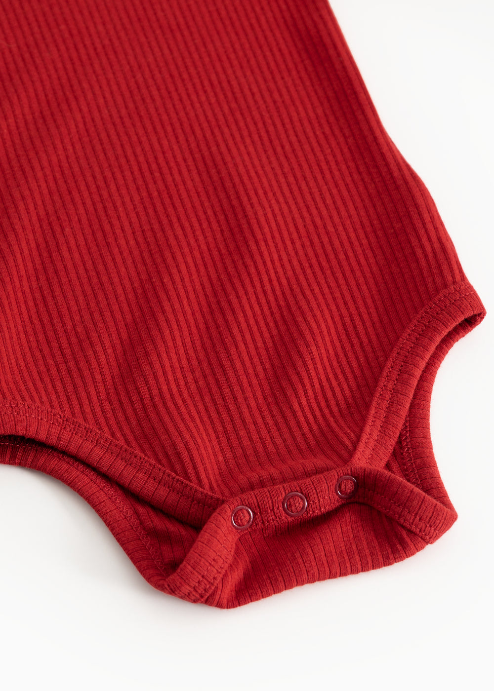 Cherry red bodystocking with ribbed pattern and snap buttons at the crotch.