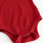 Cherry red bodystocking with ribbed pattern and snap buttons at the crotch.