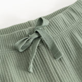 Detail of green waistband on ribbed knit pants with elastic and drawstring