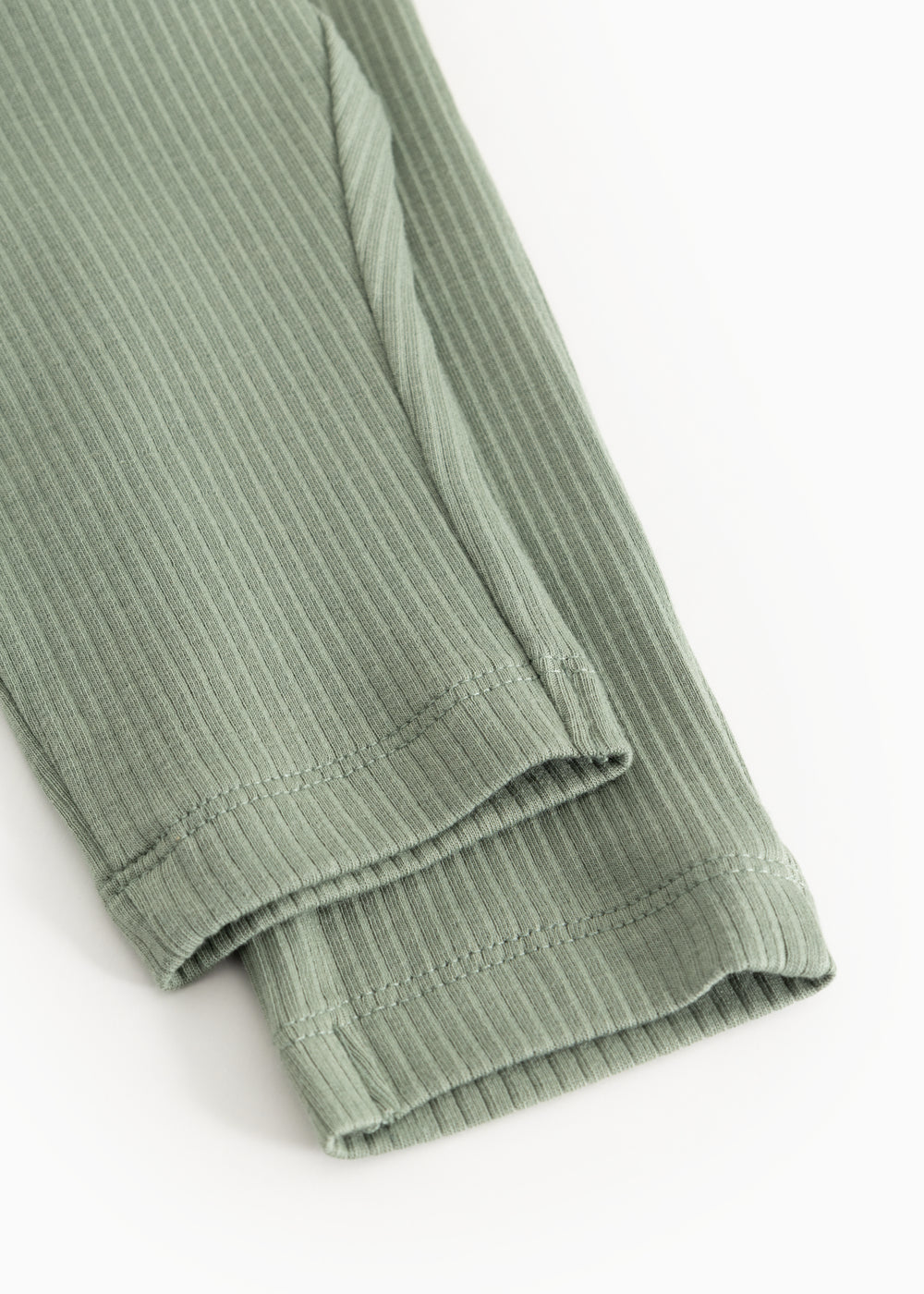 Bottom edge of green ribbed knit pants with elastic cuff