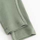 Bottom edge of green ribbed knit pants with elastic cuff