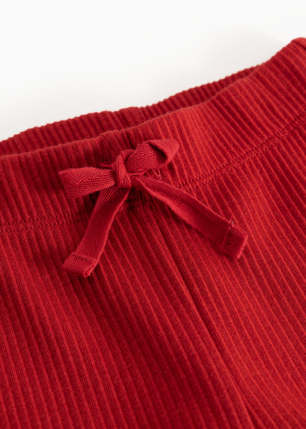 Detail of cherry red Pitti trousers with a drawstring at the waist