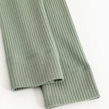 Green ribbed knit leggings with finished hem and visible seam