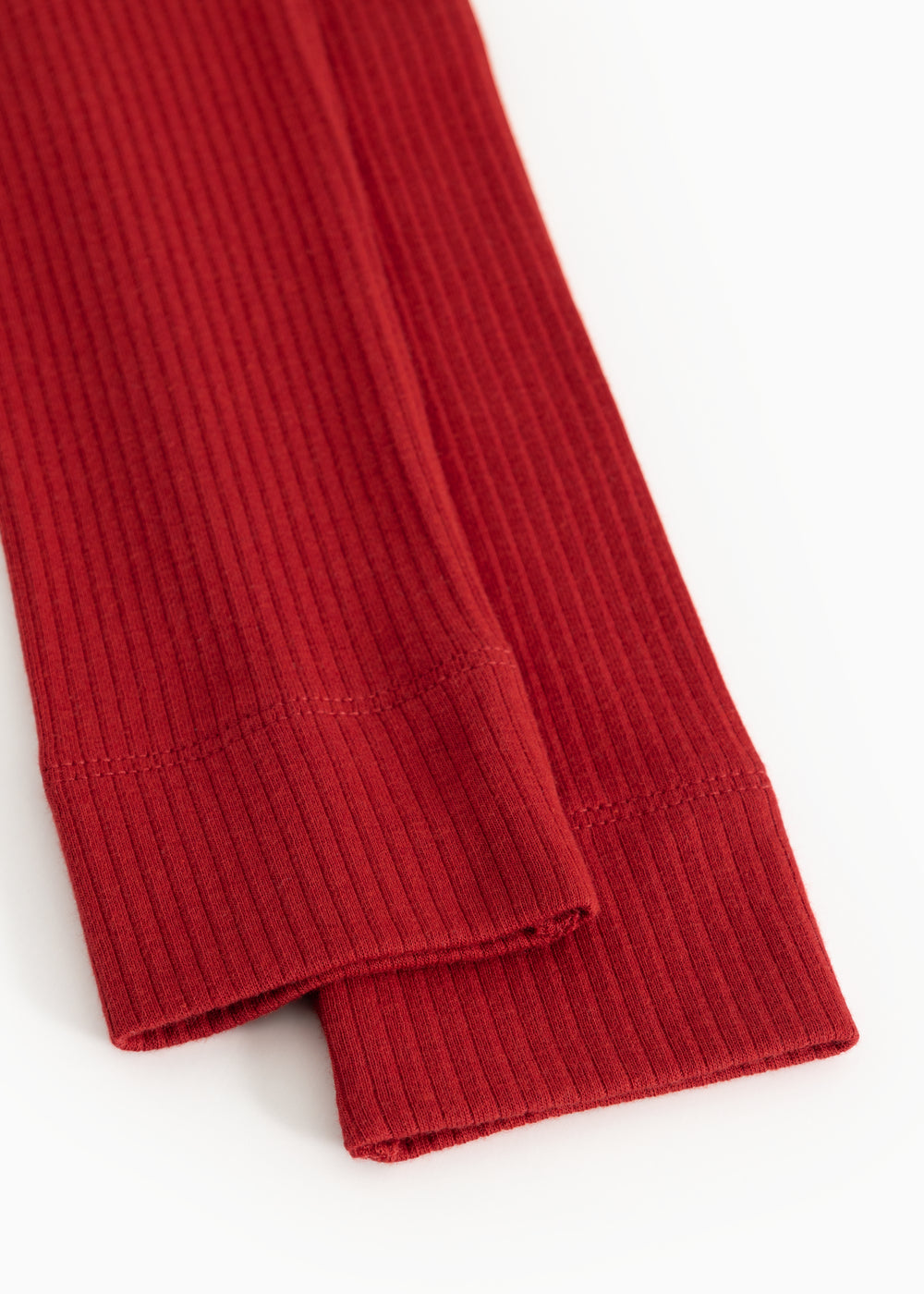 Detail of red ribbed leggings with tight elastic hem at leg opening