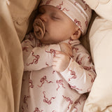 Aiko baby hat with red bows on a light background, worn by a baby