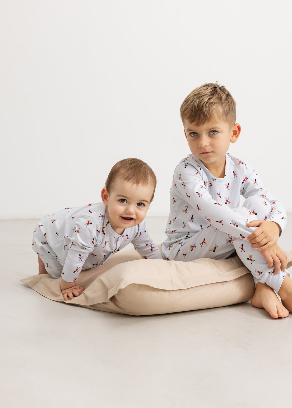 Children in white pajama set with colorful musician print: long-sleeved top and pants