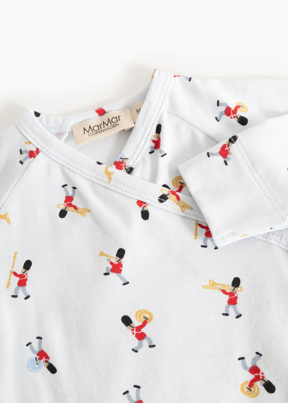 White jumpsuit with neckline and all-over musician pattern, close stitching.
