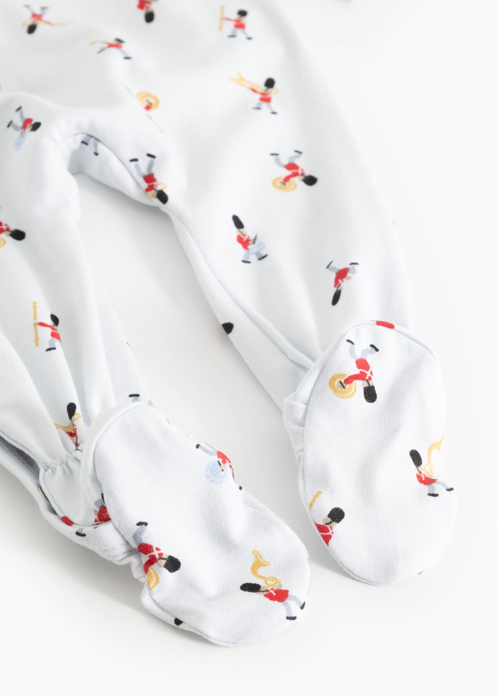White jumpsuit with tie skirt? No—featuring leg cuffs and musician pattern, detail.