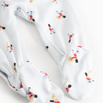 White jumpsuit with tie skirt? No—featuring leg cuffs and musician pattern, detail.