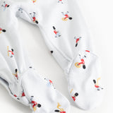 White jumpsuit with tie skirt? No—featuring leg cuffs and musician pattern, detail.