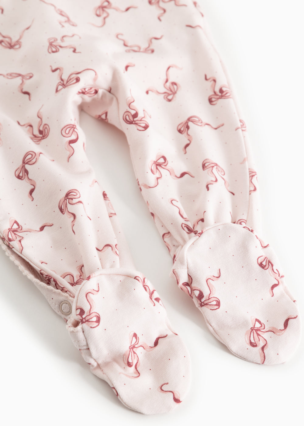 Light jumpsuit with all-over red bow pattern and long sleeves