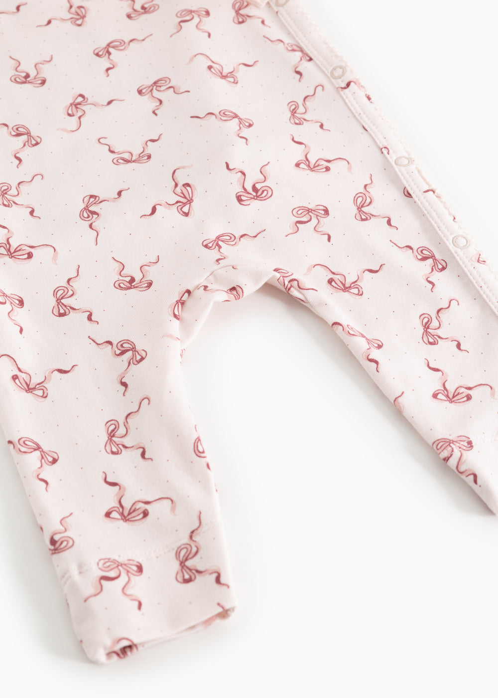 White jumpsuit with red bow print, long legs and leg openings