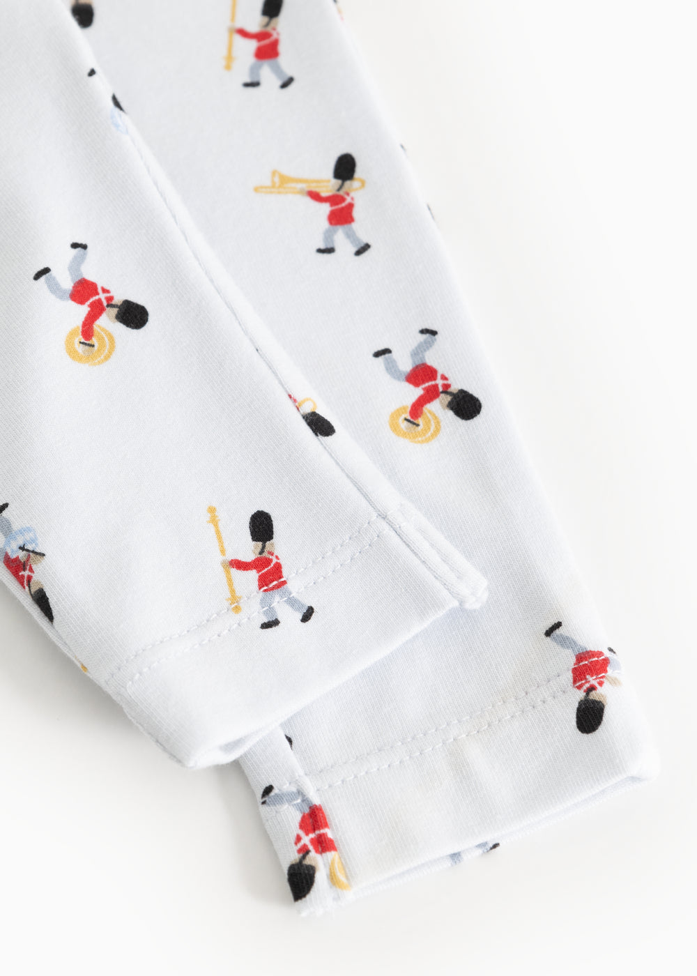 White baby pants with musician print and visible seam at leg opening