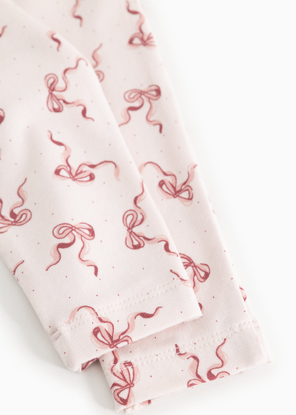 Baby pants with red bow print and visible edge at leg opening