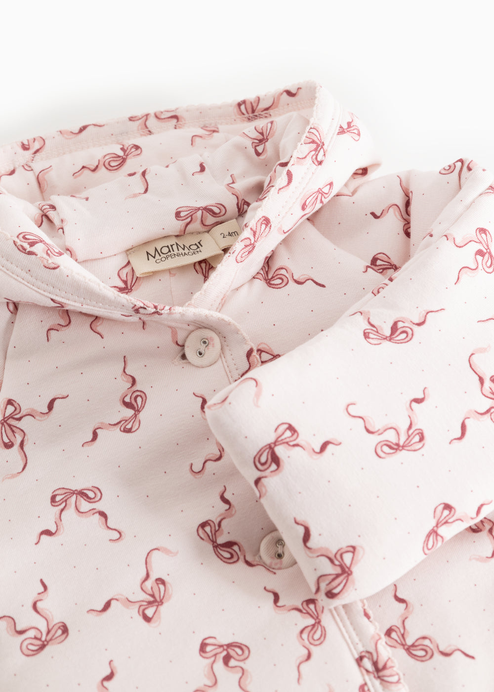 Rexa jumpsuit with hood: buttons on the collar, white with pink bows