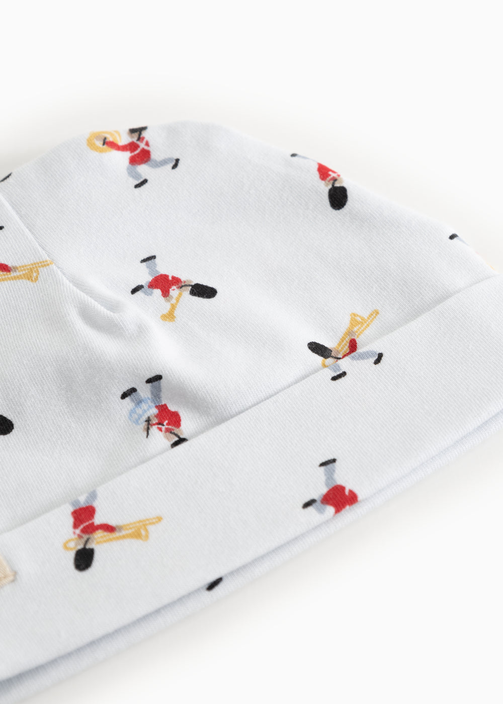 White baby hat with repeated print of musicians all over the hat
